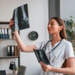 Médica olha raio-x sem se preocupar com a contabilidade médica, porque ela está em boas mãos.