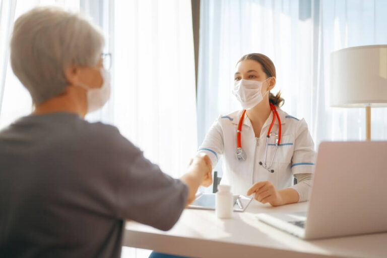 Médica com máscara atende paciente e quer saber qual é a diferença entre clínica e consultório.