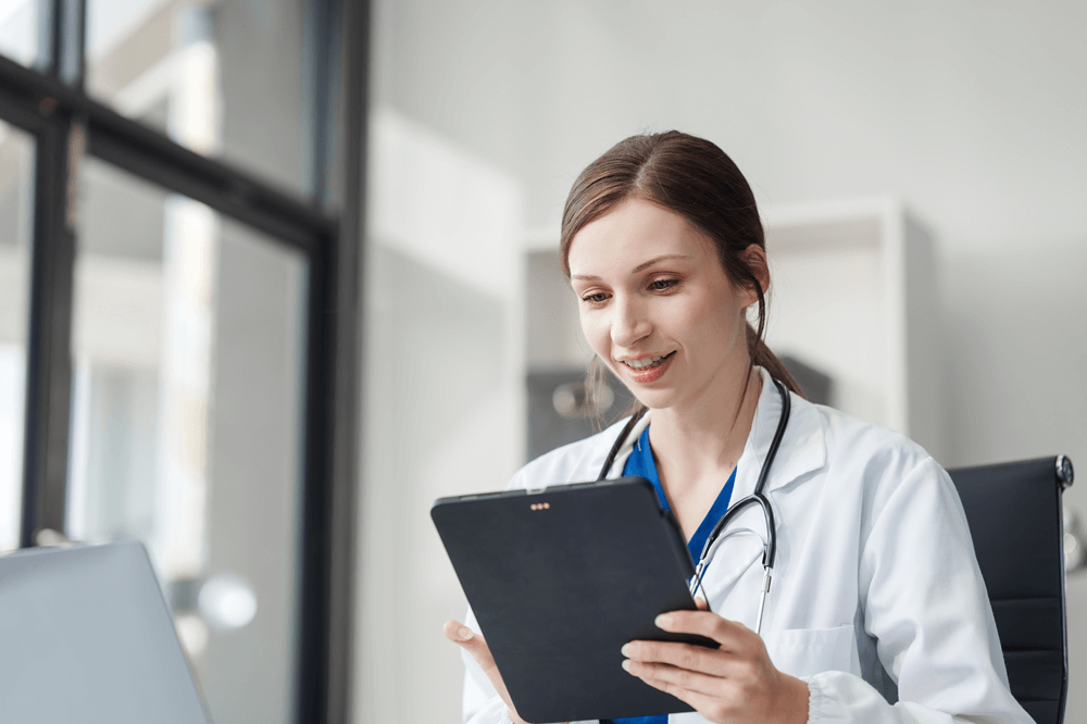 Imagem de uma profissional da área da saúde olhando o imposto de renda para médicos no tablet